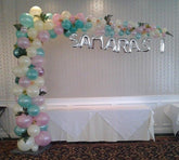 Colorful organic L-shape balloon arch with greens and custom name mylars